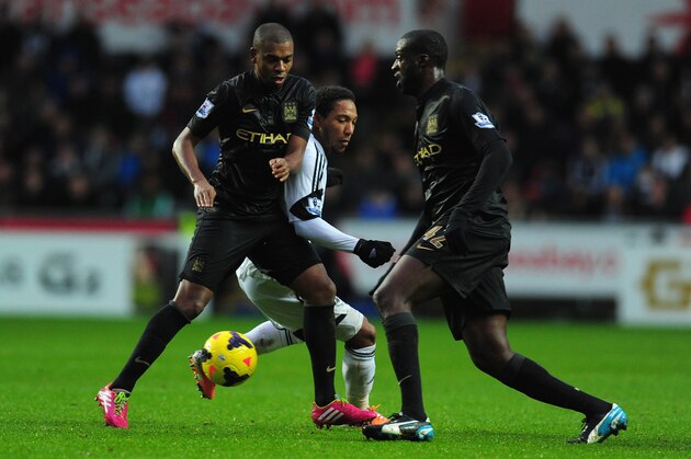 SWANSEA, WALES - JANUARY 01: Manchester City players Fernandinho (l) and Yaya Toure (r) combine to halt Jonathan de Guzman during the Barclays Premier League match between Swansea City and Manchester City at Liberty Stadium on January 1, 2014 in Swansea, Wales. (Photo by Stu Forster/Getty Images) SWANSEA, WALES - JANUARY 01: Manchester City players Fernandinho (l) and Yaya Toure (r) combine to halt Jonathan de Guzman during the Barclays Premier League match between Swansea City and Manchester City at Liberty Stadium on January 1, 2014 in Swansea, Wales. (Photo by Stu Forster/Getty Images)