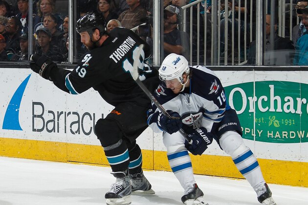 SAN JOSE, CA - MARCH 27: Joe Thornton #19 of the San Jose Sharks battles for the puck in his 1200th NHL game against Bryan Little #18 of the Winnipeg Jets during an NHL game on March 27, 2014 at SAP Center in San Jose, California. (Photo by Nick Lust/NHLI via Getty Images)