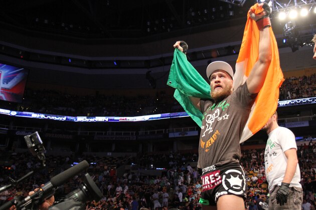 Conor McGregor, of Ireland, leaves the ring draped in an Irish flag after beathing Max Holloway in their UFC on Fox Sports 1 mixed martial arts bout in Boston, Saturday, August 17,2013. McGregor won via unanimous decision. (AP Photo/Gregory Payan)