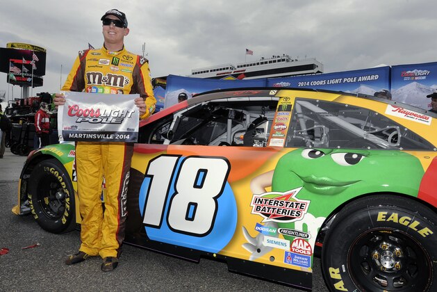 Kyle Busch poses for photos after winning the pole for Sunday's NASCAR Sprint Cup Series auto race at Martinsville Speedway in Martinsville, Va., Friday, March 28, 2014. (AP Photo/Mike McCarn)