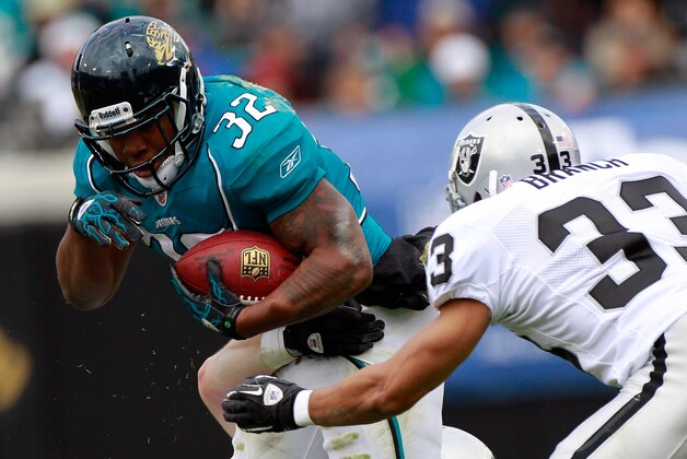 JACKSONVILLE, FL - DECEMBER 12:  Maurice Jones-Drew #32 of the Jacksonville Jaguars attempts to run past Tyvon Branch #33 of the Oakland Raiders during the game at EverBank Field on December 12, 2010 in Jacksonville, Florida.  (Photo by Sam Greenwood/Getty Images)