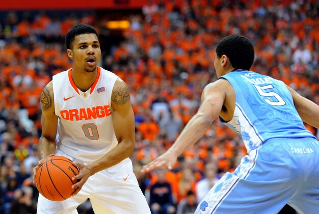 Jan 11, 2014; Syracuse, NY, USA; Syracuse Orange forward Michael Gbinije (0) scans the court against the defense of North Carolina Tar Heels guard Marcus Paige (5) during the first half at the Carrier Dome.  Mandatory Credit: Rich Barnes-USA TODAY Sports