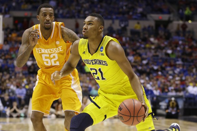 Michigan's Zak Irvin (21) drive past Tennessee's Jordan McRae (52) during the second half of an NCAA Midwest Regional semifinal college basketball tournament game Friday, March 28, 2014, in Indianapolis. (AP Photo/Michael Conroy)