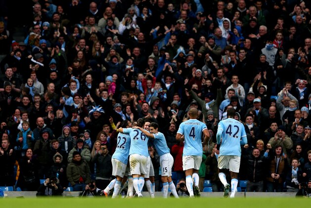 Manchester City's Fernandinho, left, fights for the ball against Arsenal's Jack Wilshere during their English Premier League soccer match at the Etihad Stadium, Manchester, England, Saturday Dec. 14, 2013. (AP Photo/Jon Super)