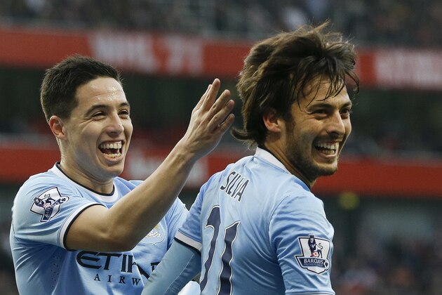 Manchester City's David Silva, right, celebrates scoring a goal with teammate Samir Nasri during the English Premier League soccer match between Arsenal and Manchester City at the Emirates stadium in London, Saturday, March 29, 2014. (AP Photo/Kirsty Wigglesworth)