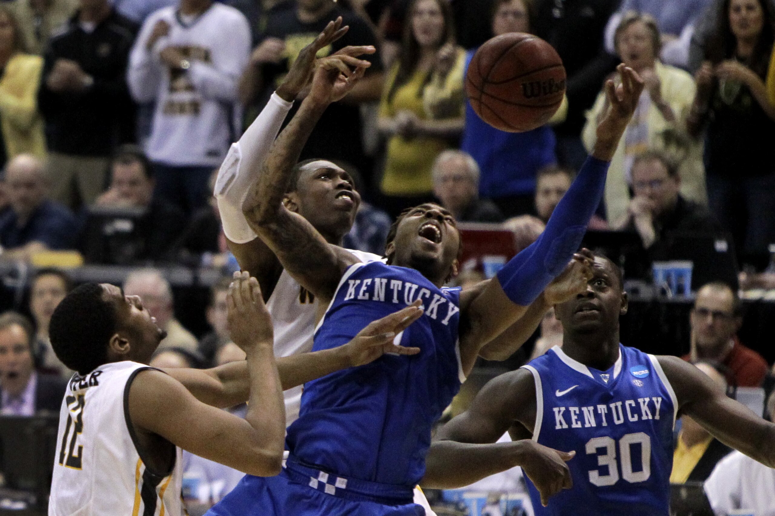 Kentucky's James Young, second from right and Wichita State's Cleanthony Early reach for a rebound as Wichita State's Darius Carter, left, and Kentucky's Julius Randle, right, watch during the second half of a third-round game of the NCAA college basketball tournament Sunday, March 23, 2014, in St. Louis. Kentucky won 78-76. (AP Photo/Jeff Roberson)