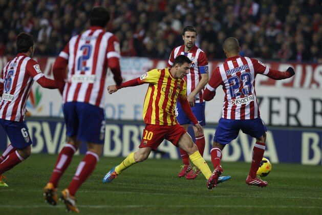 Barcelona's Lionel Messi from Argentina, center,  controls the ball  in between players  during a Spanish La Liga soccer match between Atletico de Madrid and FC Barcelona at the Vicente Calderon stadium in Madrid, Spain, Saturday, Jan. 11, 2014. (AP Photo/Gabriel Pecot)