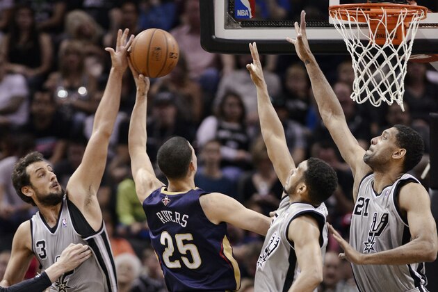 New Orleans Pelicans guard Austin Rivers (25) shoots against San Antonio Spurs forward Tim Duncan, right, and guards Marco Belinelli, left, of Italy, and Cory Joseph during the second half of an NBA basketball game on Saturday, March 29, 2014, in San Antonio. San Antonio won 96-80. (AP Photo/Darren Abate)