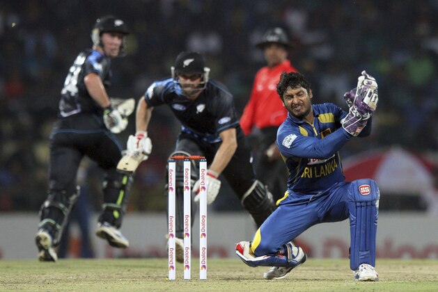 Sri Lankan wicket keeper Kumar Sangakkara, right, reacts as he fails to get the ball as New Zealand batsmen Andrew Ellis, center, and Luke Ronchi, left, run between the wickets during their second and final Twenty20 cricket match against Sri Lanka in Pallekele, Sri Lanka, Thursday, Nov. 21, 2013. The first match was abandoned due to rain. (AP Photo)