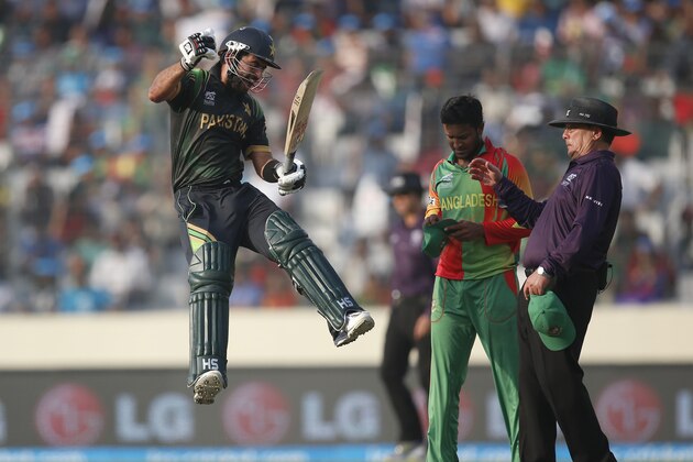 Pakistan batsman Ahmed Shehzad, left, leaps in the air to celebrate scoring a century during their ICC Twenty20 Cricket World Cup match against Bangladesh in Dhaka, Bangladesh, Sunday, March 30, 2014. (AP Photo/Aijaz Rahi)
