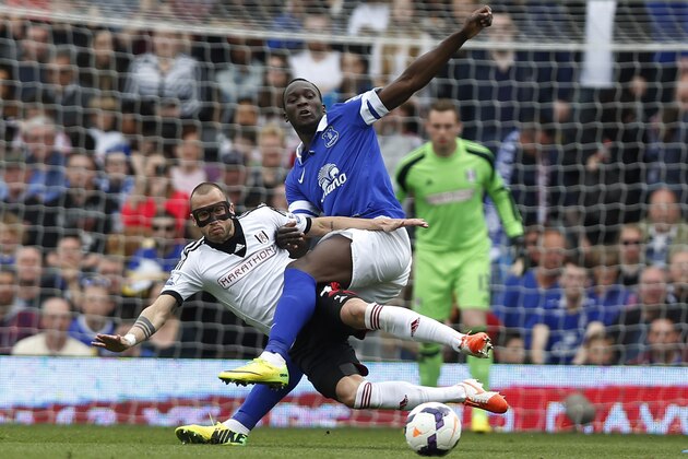 Fulham's John Heitinga, left, tussles with Everton's Romelu Lukaku during their English Premier League soccer match at Craven Cottage, London, Sunday, March 30, 2014. (AP Photo/Sang Tan)