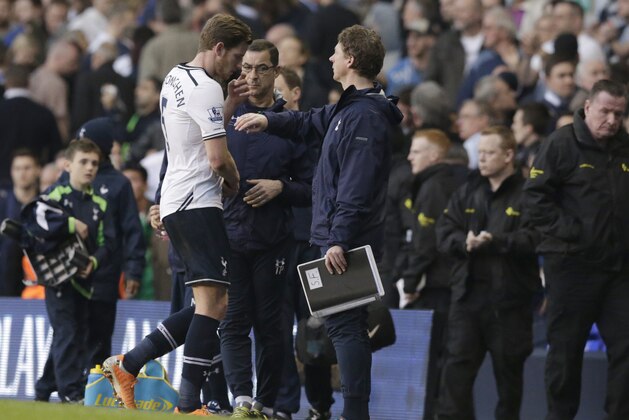 Tottenham Hotspur's Jan Vertonghen, left walks off the pitch and is given a pat on the back by Tottenham's assistant manager Stefan Freund competes for the ball with Arsenal's during the English Premier League soccer match between Tottenham Hotspur and Arsenal at White Hart Lane stadium in London, Sunday, March 16, 2014. (AP Photo/Matt Dunham)