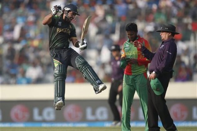 Pakistan batsman Ahmed Shehzad, left, leaps in the air to celebrate scoring a century during their ICC Twenty20 Cricket World Cup match against Bangladesh in Dhaka, Bangladesh, Sunday, March 30, 2014. (AP Photo/Aijaz Rahi)