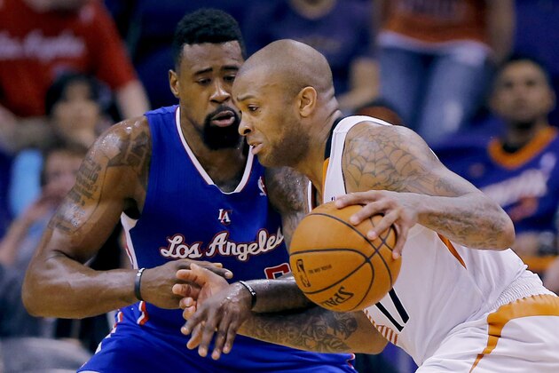 Los Angeles Clippers' DeAndre Jordan defends as Phoenix Suns' P.J. Tucker, right, drives during the first half of an NBA basketball game, Tuesday, March 4, 2014, in Phoenix. (AP Photo/Matt York)