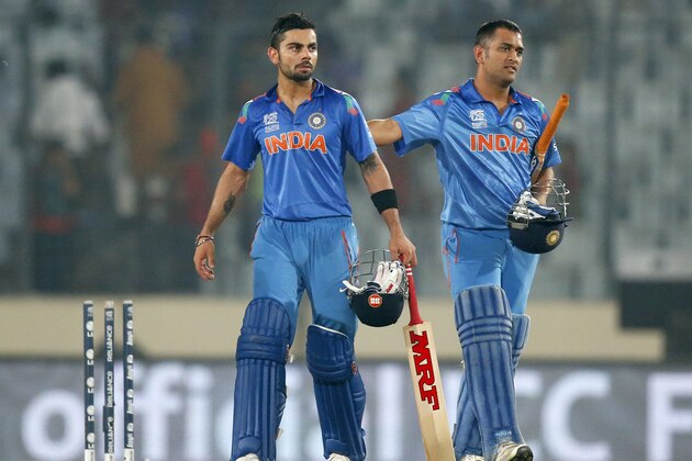India's captain Mahendra Singh Dhoni, right, and teammate Virat Kohli celebrate their win over Bangladesh in the ICC Twenty20 Cricket World Cup match in Dhaka, Bangladesh, Friday, March 28, 2014. India won the match by eight wickets. (AP Photo/Aijaz Rahi)