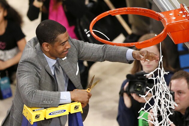 Connecticut head coach Kevin Ollie cuts the netting on the rim after his team defeating Michigan State 60-54 during a regional final at the NCAA college basketball tournament, Sunday, March 30, 2014, in New York. (AP Photo/Julio Cortez)