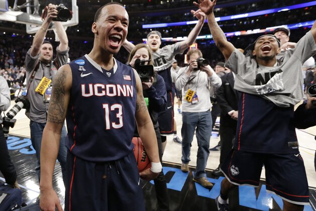 Connecticut's Shabazz Napier (13) celebrates after his team defeated Michigan State 60-54 in a regional final at the NCAA college basketball tournament, Sunday, March 30, 2014, in New York. Napier scored 17 points of his 25 points in the second half. (AP Photo/Frank Franklin II)