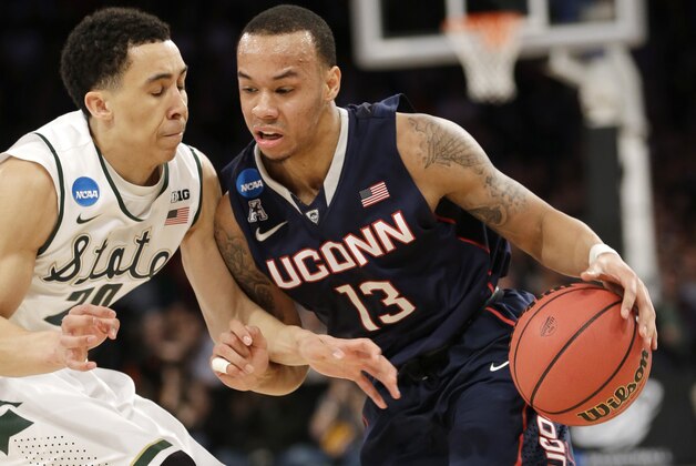 Connecticut's Shabazz Napier, right, moves the ball around Michigan State's Travis Trice in the first half of a regional final at the NCAA college basketball tournament on Sunday, March 30, 2014, in New York. (AP Photo/Seth Wenig)