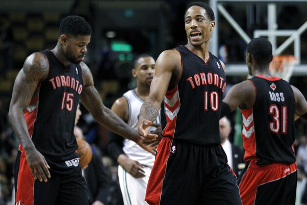 Toronto Raptors guard DeMar DeRozan (10) and forward Amir Johnson (15) congratulate each other as they walk off the court after defeating the Boston Celtics 99-90 in an NBA basketball game in Boston, Wednesday, March 26, 2014. (AP Photo/Elise Amendola)