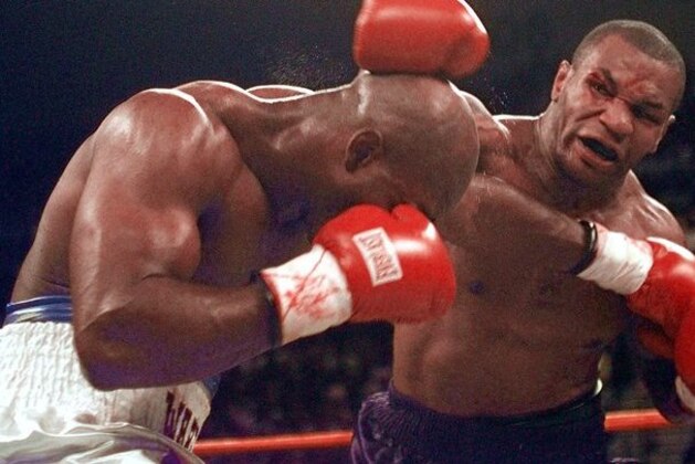 Mike Tyson and Evander Holyfield exchange punches during their WBA Heavyweight match Saturday, June 28, 1997, at the MGM Grand in Las Vegas.  The fight was stopped after Tyson bit Holyfield on each ear during the third round. Tyson was disqualified and Holyfield retained his title. (AP Photo/Lenny Ignelzi)