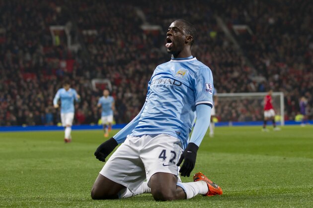 Manchester City's Yaya Toure celebrates after scoring against Manchester United during their English Premier League soccer match at Old Trafford Stadium, Manchester, England, Tuesday, March 25, 2014. (AP Photo/Jon Super)