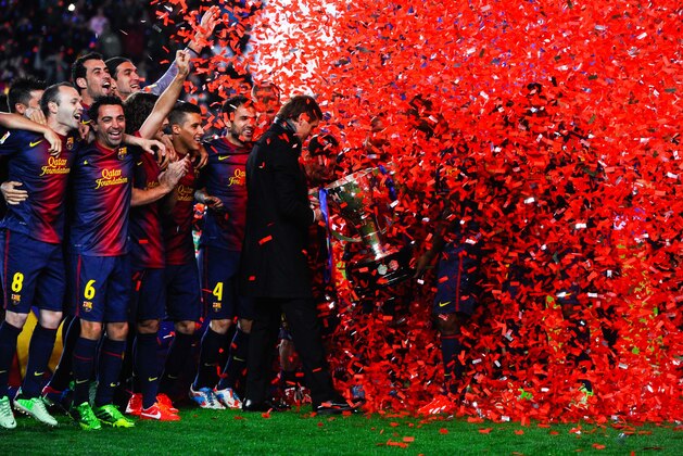BARCELONA, SPAIN - MAY 19:  Head coach Tito Vilanova holds the trophy as his players celebrate during the celebration after winning the Spanish League after the La Liga match between FC Barcelona and Real Valladolid CF at Camp Nou on May 19, 2013 in Barcelona, Spain.  (Photo by David Ramos/Getty Images)