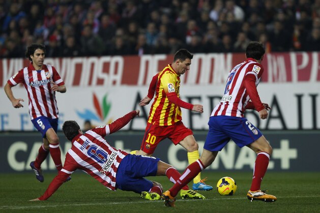 Barcelona's Lionel Messi from Argentina, center,  controls the ball  in between players  during a Spanish La Liga soccer match between Atletico de Madrid and FC Barcelona at the Vicente Calderon stadium in Madrid, Spain, Saturday, Jan. 11, 2014. (AP Photo/Gabriel Pecot)
