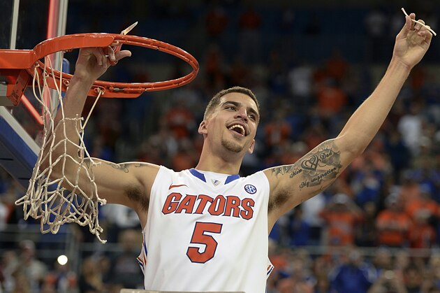Florida guard Scottie Wilbekin (5) holds up a piece of the net after the Gators became the first team in Southeastern Conference history to go 18-0 in league pla, Saturday, March 8, 2014 in Gainesville, Fla.    Florida defeated Kentucky 84-65 Saturday in an NCAA college basketball game. (AP Photo/Phil Sandlin)