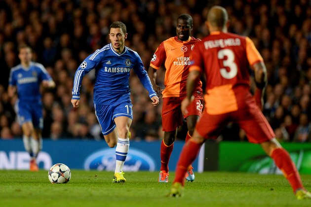 LONDON, ENGLAND - MARCH 18:  Eden Hazard of Chelsea takes on Emmanuel Eboue (27) and Felipe Melo of Galatasaray (3) during the UEFA Champions League Round of 16 second leg match between Chelsea and Galatasaray AS at Stamford Bridge on March 18, 2014 in London, England.  (Photo by Mike Hewitt/Getty Images)