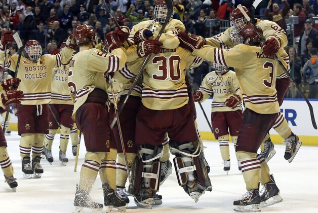 Boston College players mob goalie Thatcher Demko (30) after they defeated UMass Lowell 4-3 in the NCAA Northeast Regional hockey final in Worcester, Mass., Sunday, March 30, 2014. (AP Photo/Elise Amendola)
