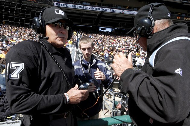 First base umpire Bob Davidson, right, and home plate umpire John Hirschbeck, left, talk over headsets as a play at first base is being reviewed in the fifth inning during the opening day baseball game between the Pittsburgh Pirates and the Chicago Cubs on Monday, March 31, 2014, in Pittsburgh. Chicago Cubs manager Rick Renteria requested a replay on an out call. (AP Photo/Gene Puskar)