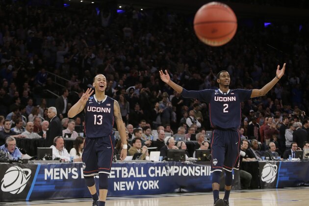 Connecticut's Shabazz Napier (13) and DeAndre Daniels (2) gesture to their teammates during the second half of a regional final against Michigan State in the NCAA college basketball tournament, Sunday, March 30, 2014, in New York. Connecticut won 60-54. (AP Photo/Frank Franklin II)