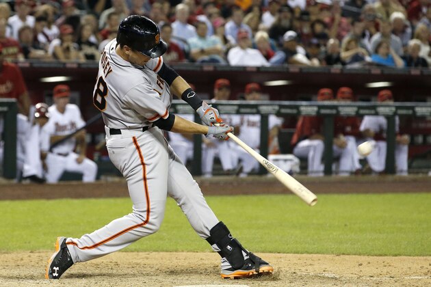 San Francisco Giants' Buster Posey connects for a 2-run home run against the Arizona Diamondbacks during the ninth inning of an opening day baseball game, Monday, March 31, 2014, in Phoenix. (AP Photo/Ross D. Franklin)