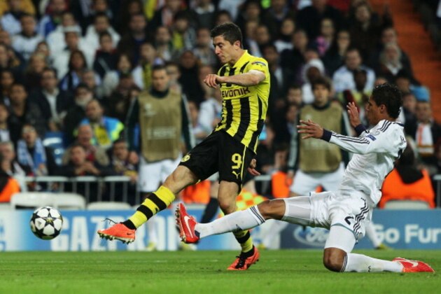 MADRID, SPAIN - APRIL 30:  Robert Lewandowski of Borussia Dortmund shoots past Raphael Varane of Real Madrid during the UEFA Champions League Semi Final Second Leg match between Real Madrid and Borussia Dortmund at Estadio Santiago Bernabeu on April 30, 2013 in Madrid, Spain.  (Photo by Gonzalo Arroyo Moreno/Getty Images)
