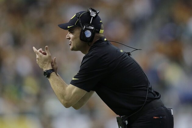 Oregon coach Mark Helfrich talks to his players during the first half of the Valero Alamo Bowl NCAA college football game against Texas, Monday,  Dec. 30, 2013, in San Antonio. Oregon won 30-7.  (AP Photo/Eric Gay)