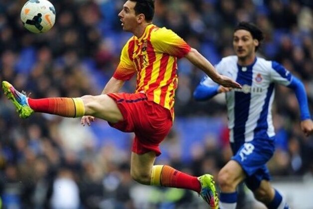 FC Barcelona's Lionel Messi, left, duels for the ball against Espanyol's Diego Colotto during a Spanish La Liga soccer match against Espanyol at Cornella-El Prat stadium in Cornella Llobregat, Spain, Saturday, March 29, 2014. (AP Photo/Manu Fernandez)