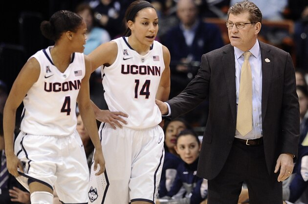 Connecticut head coach Geno Auriemma, right, speaks with Moriah Jefferson, left, and Bria Hartley, center, during the first half of an NCAA college basketball game against Rutgers in the semifinals of the American Athletic Conference women's tournament, Sunday, March 9, 2014, in Uncasville, Conn. (AP Photo/Jessica Hill)