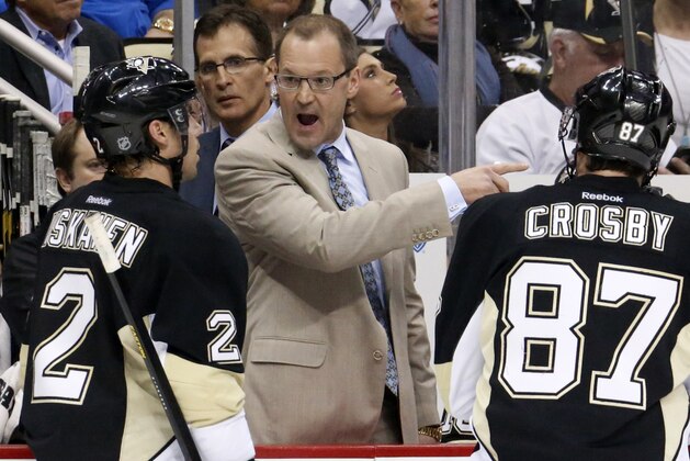 Pittsburgh Penguins' Dan Bylsma, center, gives instructions to Matt Niskanen (2), and Sidney Crosby (87) during a time out in the third period of an NHL hockey game against the Chicago Blackhawks  in Pittsburgh, Sunday, March 30, 2014. The Penguins won 4-1. (AP Photo/Gene J. Puskar)
