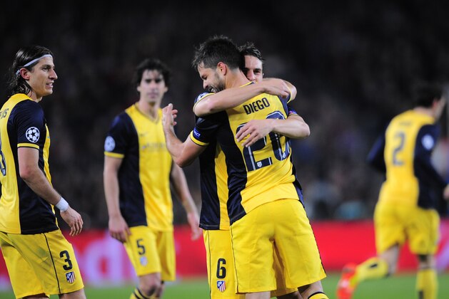 Atletico's Diego, centre celebrates with  Koke after scoring during a first leg quarterfinal Champions League soccer match between Barcelona and Atletico Madrid at the Camp Nou stadium in Barcelona, Spain, Tuesday April 1, 2014. (AP Photo/Manu Fernandez)