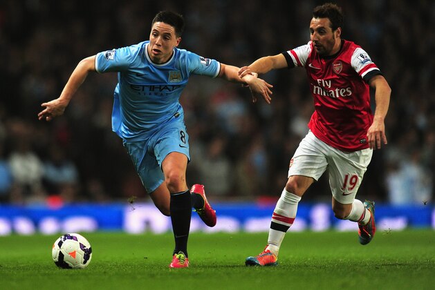 LONDON, ENGLAND - MARCH 29:  Samir Nasri of Manchester City and Santi Cazorla of Arsenal battle for the ball during the Barclays Premier League match between Arsenal and Manchester City at Emirates Stadium on March 29, 2014 in London, England.  (Photo by Shaun Botterill/Getty Images)