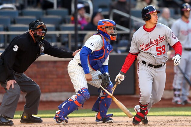 NEW YORK, NY - MARCH 31:  Jose Lobaton #59 of the Washington Nationals breaks his bat as he hits a single in the 10th inning as Travis d'Arnaud #15 of the New York Mets defends during Opening Day on March 31, 2014 at Citi Field in the Flushing neighborhood of the Queens borough of New York City.The Washington Nationals defeated the New York Mets 9-7 in 10 innings.  (Photo by Elsa/Getty Images)