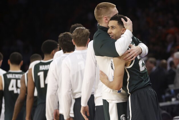 Michigan State's Russell Byrd, second from right, and Travis Trice embrace after their team defeated Virginia 61-59 in a regional semifinal of the NCAA men's college basketball tournament, Saturday, March 29, 2014, in New York. (AP Photo/Frank Franklin II)
