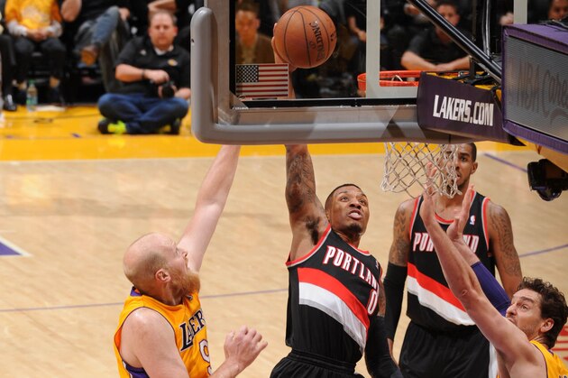 LOS ANGELES, CA - APRIL 1: Damian Lillard #0 of the Portland Trail Blazers dunks against Chris Kaman #9 and Pau Gasol #16 of the Los Angeles Lakers at Staples Center on April 1, 2014 in Los Angeles, California. NOTE TO USER: User expressly acknowledges and agrees that, by downloading and/or using this Photograph, user is consenting to the terms and conditions of the Getty Images License Agreement. Mandatory Copyright Notice: Copyright 2014 NBAE (Photo by Andrew D. Bernstein/NBAE via Getty Images)