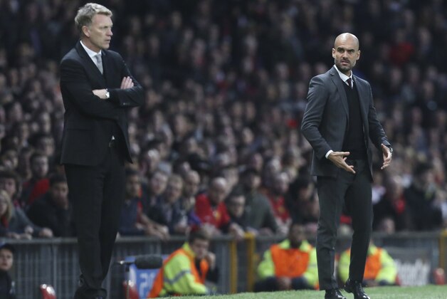 Manchester United's manager David Moyes, left, and Bayern head coach Pep Guardiola watch the Champions League quarterfinal first leg soccer match between Manchester United and Bayern Munich at Old Trafford Stadium, Manchester, England, Tuesday, April 1, 2014.(AP Photo/Jon Super)