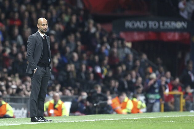 Bayern head coach Pep Guardiola watches the Champions League quarterfinal first leg soccer match between Manchester United and Bayern Munich at Old Trafford Stadium, Manchester, England, Tuesday, April 1, 2014.(AP Photo/Jon Super)