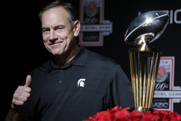 Michigan State head coach Mark Dantonio poses by the Trophy after a news conference in Los Angeles, Monday, Dec. 30, 2013. Michigan State is to face Stanford in the 100th Rose Bowl NCAA college football game on New Year's Day. (AP Photo/Chris Carlson)