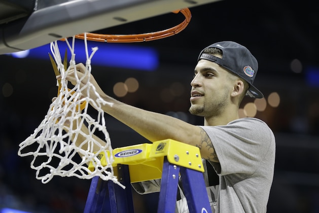 Florida guard Scottie Wilbekin cuts part of the net after the second half in a regional final game against Dayton at the NCAA college basketball tournament, Saturday, March 29, 2014, in Memphis, Tenn. Florida won 62-52. (AP Photo/Mark Humphrey)
