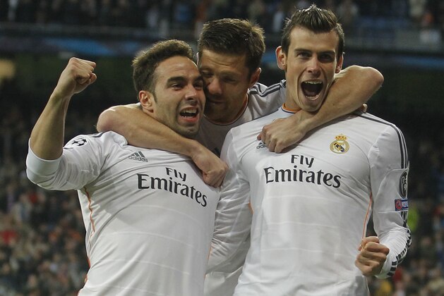 Real's Gareth Bale, right, celebrates scoring the opening goal with Real's Daniel Carvajal, left, and Xabi Alonso, center, during a Champions League quarterfinal first leg soccer match between Real Madrid and Borussia Dortmund at the Santiago Bernabeu   stadium in Madrid, Spain, Wednesday April 2, 2014. (AP Photo/Paul White)