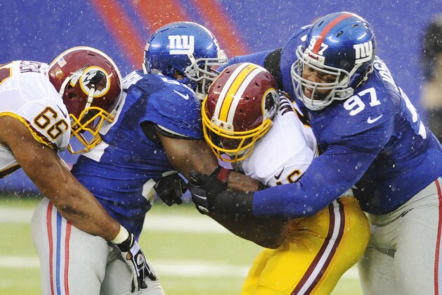 New York Giants defensive tackle Linval Joseph (97) and linebacker Jon Beason (52) tackles Washington Redskins' Alfred Morris during the first half of an NFL football game Sunday, Dec. 29, 2013, in East Rutherford, N.J.  Redskins' Chris Chester (66) moves in on the play. (AP Photo/Bill Kostroun)