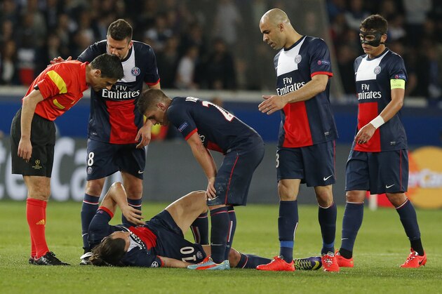 Paris Saint-Germain's Zlatan Ibrahimovic lies on the ground injured as his teammates and the referee look on during a Champions League quarterfinal first leg soccer match between Paris Saint-Germain and Chelsea at Parc des Princes stadium in Paris, Wednesday, April 2, 2014. (AP Photo/Michel Euler)